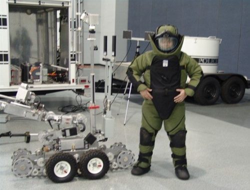 An EOD Technician with a robot used in explosives detection and disarmament.